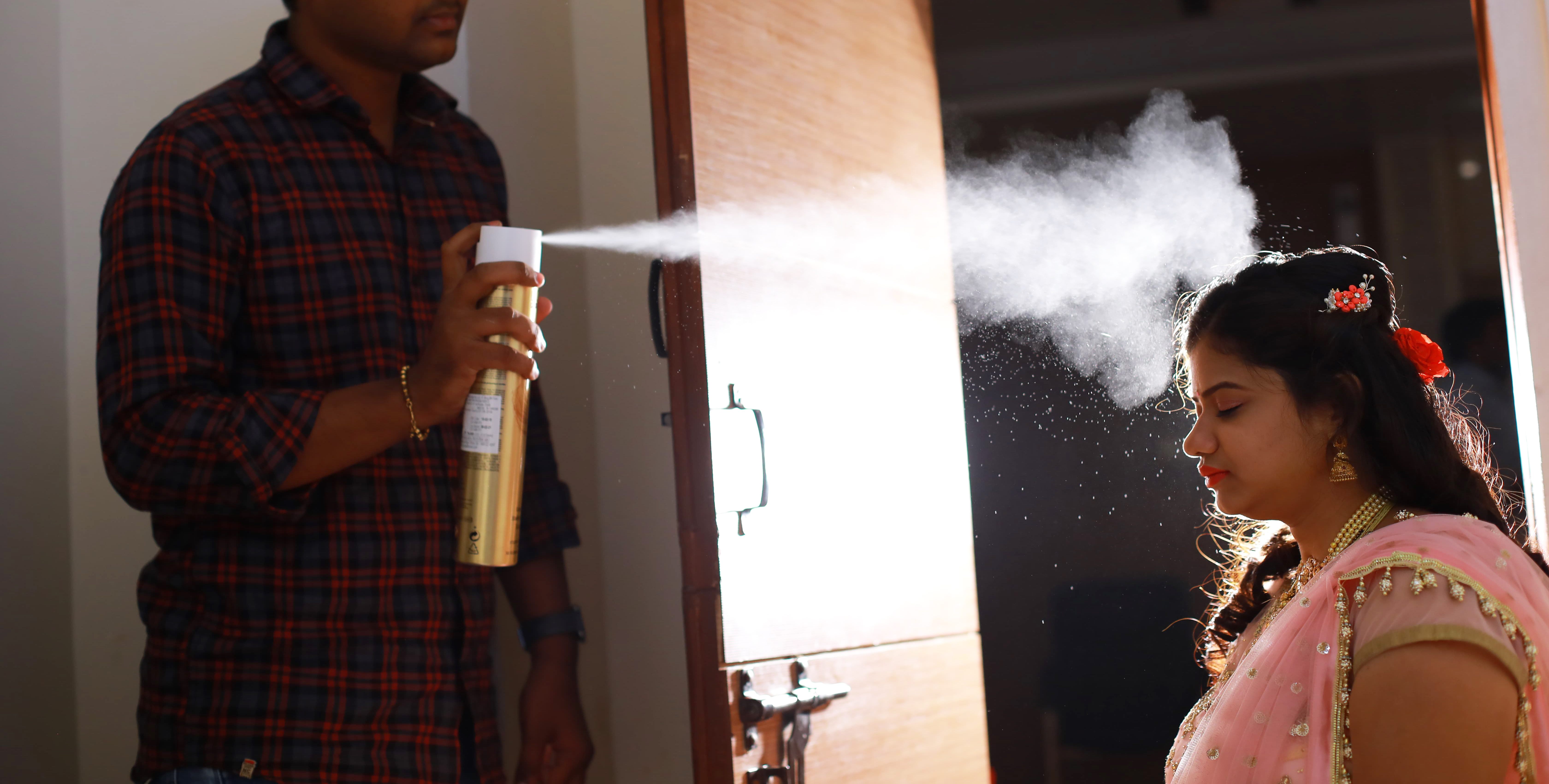 bridal hair spray preparation Hyderabad makeup artist spraying hair
